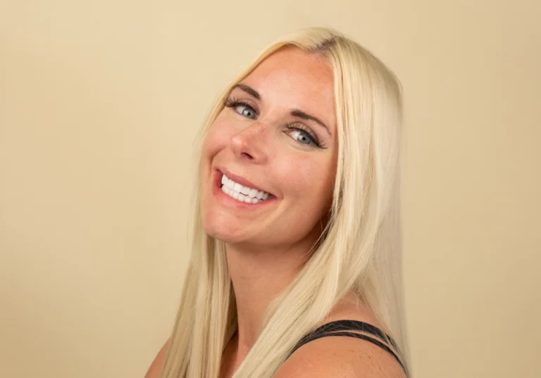 Headshot of a patient displaying an even, natural smile after smile design treatment